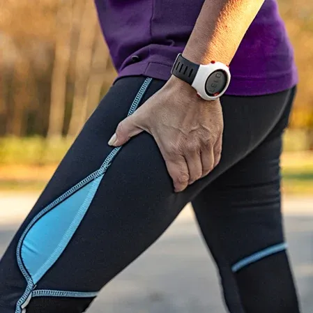 Person gripping the thigh during exercise, illustrating sciatica pain, nerve irritation, or muscle strain.